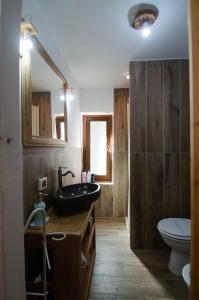 ein Bad mit einem schwarzen Waschbecken und einem WC in der Unterkunft Borgo Don Camillo in Cutigliano
