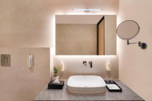 een badkamer met een wastafel en een spiegel bij Lemon Tree Hotel, Haridwar in Haridwār