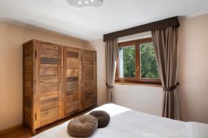 een slaapkamer met een bed, een houten kast en een raam bij La Vigne De Papagran App3 in Aosta