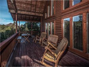 a deck with chairs and a table on a cabin at Wine N Pines in Alto