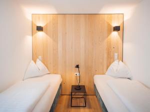 two beds in a room with wooden walls at Apartment Roman by Interhome in Stams