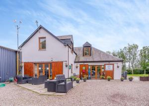 a house with a patio with chairs in front of it at Nethercraig Holiday Park in Alyth