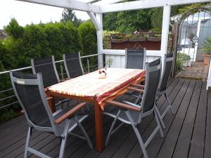 a table with chairs and a cat sitting on a deck at Holiday Home Bellevue by Interhome in Bad Sachsa