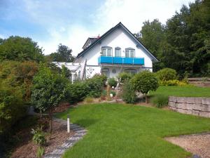 ein weißes Haus mit Rasen davor in der Unterkunft Holiday Home Bellevue by Interhome in Bad Sachsa