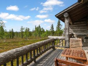 een houten terras met een bank in een cabine bij Holiday Home Kelopirtti a by Interhome in Saariselkä
