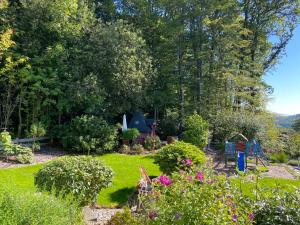 a garden with colorful flowers and trees in the background at Holiday Home Bellevue by Interhome in Bad Sachsa