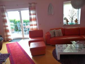 ein Wohnzimmer mit einem roten Sofa und einem Tisch in der Unterkunft Holiday Home Bellevue by Interhome in Bad Sachsa