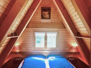 a room with a blue bed in a attic at Chalet Cermis in Cavalese