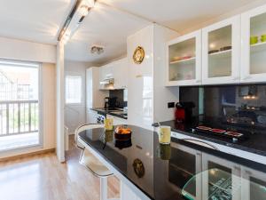 a kitchen with white cabinets and a black counter top at Apartment Cap Cabourg-31 by Interhome in Cabourg