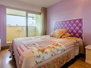 a bedroom with a purple bed with a purple headboard at Apartment Cap Cabourg-31 by Interhome in Cabourg