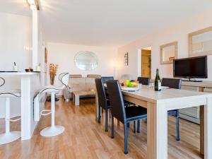 ein Esszimmer und ein Wohnzimmer mit einem Tisch und Stühlen in der Unterkunft Apartment Cap Cabourg-31 by Interhome in Cabourg