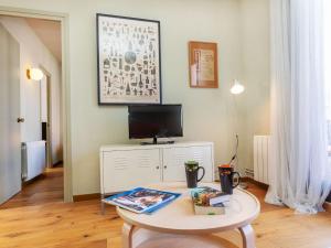 uma sala de estar com uma mesa e uma televisão em Apartment Gràcia- Parc Güell by Interhome em Barcelona
