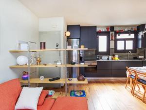 a living room with a couch and a kitchen at Apartment Gràcia- Parc Güell by Interhome in Barcelona