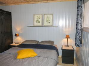 a bedroom with a bed with a yellow pillow on it at Holiday Home Friabu - SOW143 by Interhome in Fossdal