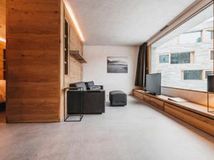 sala de estar con TV y ventana en Apartment rocksresort-8 by Interhome, en Laax