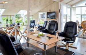 Nørre VorupørにあるAwesome Home In Thisted With 3 Bedrooms And Wifiの椅子、テーブル、テレビが備わる客室です。