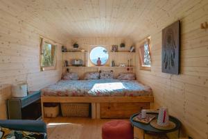 1 dormitorio en una cabaña de madera con 1 cama. en Meadowland - Samota Stříbrník, 