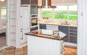 a kitchen with white cabinets and a counter top at 4 Bedroom Awesome Home In Karby in Karby
