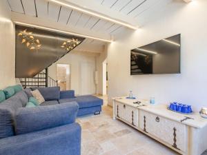 a living room with a blue couch and a table at Holiday Home Malanuit by Interhome in Bauduen