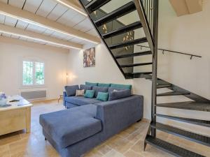 a living room with a blue couch and a staircase at Holiday Home Malanuit by Interhome in Bauduen