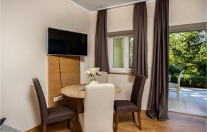 Habitación de hotel con mesa, sillas y TV en Amazing Apartment In Crikvenica With Outdoor Swimming Pool, en Crikvenica