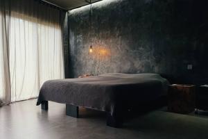 - une chambre avec un lit dans une pièce sombre dans l'établissement SURFLAB VILLA, à Balian