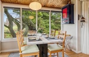 ein Esszimmer mit einem Tisch, Stühlen und einem Fenster in der Unterkunft Gorgeous Home In Fan With Kitchen in Fanø