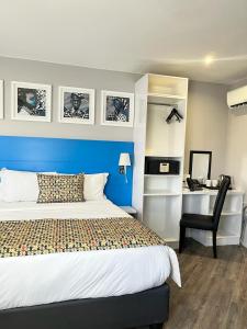 a bedroom with a bed and a desk with a chair at ONOMO Hotel Johannesburg Sandton in Johannesburg