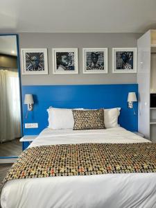 Un dormitorio con una pared azul y una cama grande en ONOMO Hotel Johannesburg Sandton, en Johannesburgo