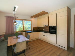 a kitchen with white cabinets and a wooden table at Apartment Mäuerlhof by Interhome in Hart im Zillertal