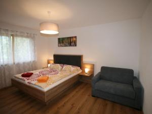 a bedroom with a bed and a chair at Apartment Mäuerl by Interhome in Hart im Zillertal