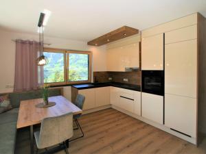 a kitchen with white cabinets and a wooden table at Apartment Mäuerl by Interhome in Hart im Zillertal
