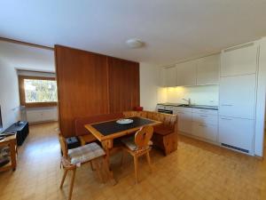 uma cozinha com mesa e cadeiras num quarto em Apartment Casa Fadail Seura 11 by Interhome em Lenzerheide