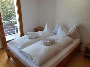 uma cama branca com duas almofadas em cima em Apartment Casa Fadail Seura 11 by Interhome em Lenzerheide