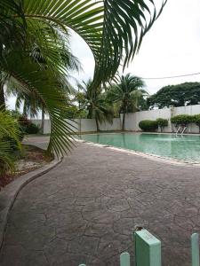a swimming pool with a palm tree next to it at Butterworth homey House (3R2B + carpark) in Butterworth