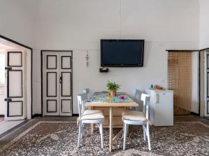 een eetkamer met een tafel en stoelen en een tv bij Apartment Elisa by Interhome in Imperia