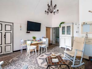 een woonkamer met een tafel en stoelen en een televisie bij Apartment Elisa by Interhome in Imperia