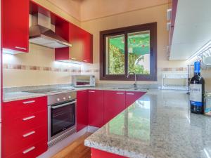 une cuisine avec des placards rouges et un comptoir dans l'établissement Villa Sa Teulada by Interhome, à Santa Margalida