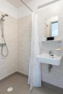 a bathroom with a sink and a shower with a mirror at B - HOME Apartments in Koblenz