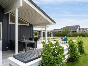 a patio with a table and chairs on it at Holiday Home Skaghi - 500m from the sea in Sealand by Interhome in Føllenslev