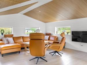 a living room with a couch and a table and a tv at Holiday Home Christl - 1km from the sea in Western Jutland by Interhome in Vejers Strand