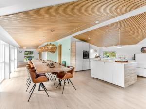 cocina y comedor con mesa de madera y sillas en Holiday Home Christl - 1km from the sea in Western Jutland by Interhome en Vejers Strand