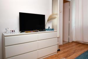 ブダペストにあるLavender Apartmentの部屋のドレッサーの上にテレビが付いています。 +6枚の写真