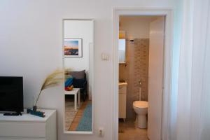 a bathroom with a mirror and a toilet in a room at Lavender Apartment in Budapest