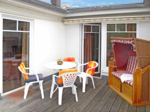 Un patio con una mesa y sillas en un porche. en Apartment Luise von Preußen - App-201 by Interhome, en Zinnowitz