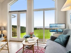sala de estar con ventanas grandes y TV en Holiday Home Evelin - 20m from the sea in Funen by Interhome, en Bogentved