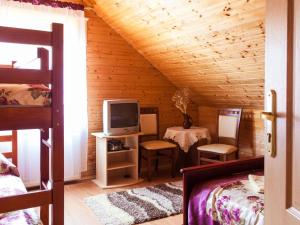 a bedroom with a bed and a tv and a table at Holiday Home Antoś by Interhome in Baligród