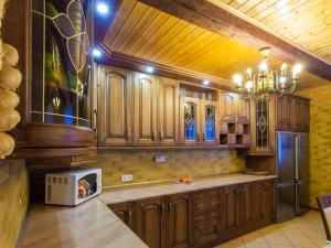 a kitchen with wooden cabinets and a stainless steel refrigerator at Holiday Home Antoś by Interhome in Baligród