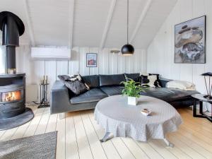 ein Wohnzimmer mit einem Sofa und einem Kamin in der Unterkunft Holiday Home Awenasa - 4-1km from the sea in Western Jutland by Interhome in Nørre Nebel