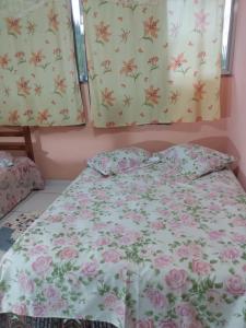 um quarto com uma cama com flores nas paredes em Apartamento em Chácara Aconchegante em Angra dos Reis